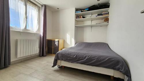 une chambre avec un lit dans une pièce avec une fenêtre dans l'établissement Appartement moderne à Uzès, 70 m², proche centre-ville, à Uzès