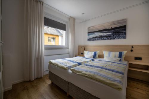 Schlafzimmer mit einem Bett und einem Fenster in der Unterkunft Haus Sabina in Helgoland