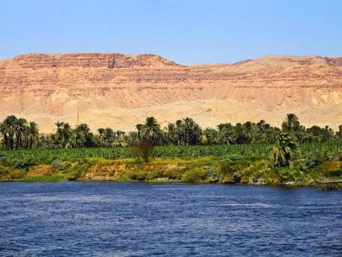 un río con palmeras y una montaña en el fondo en Luxor west bank, en Luxor