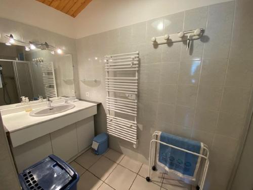 une salle de bain avec un lavabo et un miroir dans l'établissement Maison de vacances 500 m de la plage, à Sion-sur-lʼOcéan