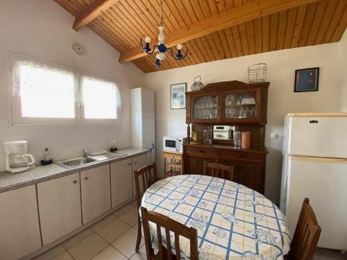 La cuisine est équipée d'une table, d'un évier et d'un réfrigérateur. dans l'établissement Maison de vacances 500 m de la plage, à Sion-sur-lʼOcéan
