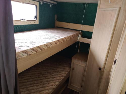 ヘルシンキにあるHelsinki's Caravan Adventureヅのベッドと窓が備わる小さな客室です。