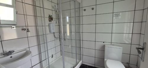 a bathroom with a shower and a toilet and a sink at The Holmlea in Blackpool
