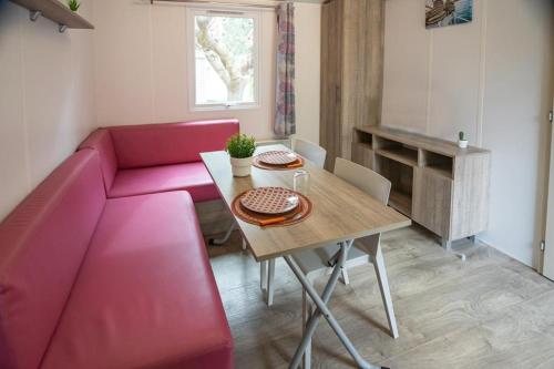 a living room with a pink couch and a table at Camping La Torre del Sol - Maeva Vacansoleil in Miami Platja