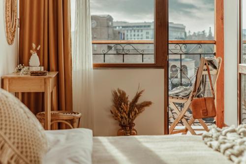 a bedroom with a bed and a view of a balcony at BOHORIA Studio Apartments - Old Town in Veliko Tŭrnovo