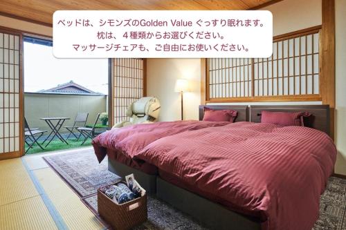 a bedroom with a large bed with a red comforter at KOTO TEA HOUSE - Vacation STAY 12808 in Kumamoto