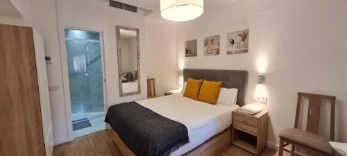 a bedroom with a large bed with yellow pillows at Suits recién reformadas Marqués de Vadillo in Madrid