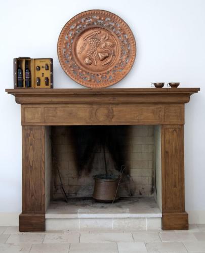 a wooden table with a shield on top of a fireplace at Relais Masseria Cardillo in Metaponto