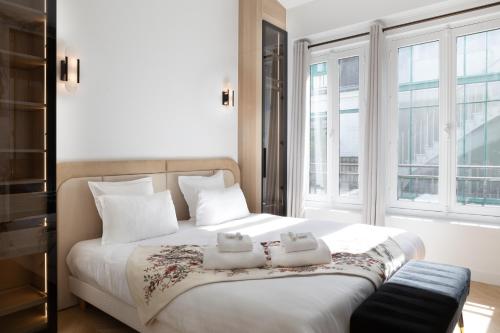 une chambre avec un grand lit avec deux serviettes dessus dans l'établissement Pick A Flat's Apartment in Montorgueil - Rue Bachaumont, à Paris