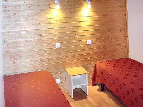 Cette chambre comprend un lit, une table et un mur. dans l'établissement Bungalow paisible à Agde avec piscine partagée, à Agde