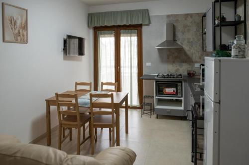 eine Küche und ein Esszimmer mit einem Tisch und Stühlen in der Unterkunft Vitti Apartment in Nettuno