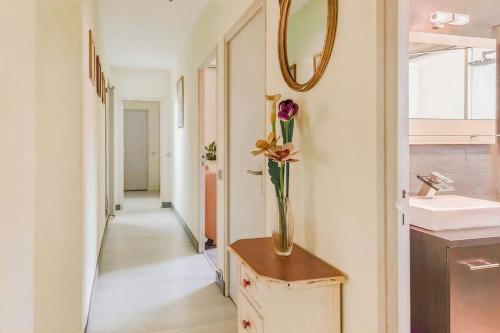 La salle de bains est pourvue d'un vase avec une fleur sur une table. dans l'établissement Villa de Luxe à La Grande Motte - Piscine - WIFI, à La Grande Motte