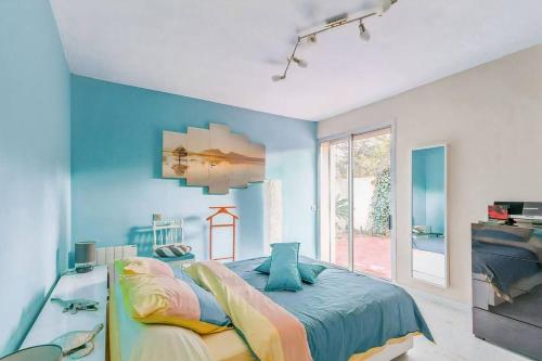 une chambre avec des murs bleus et un grand lit dans l'établissement Villa de Luxe à La Grande Motte - Piscine - WIFI, à La Grande Motte