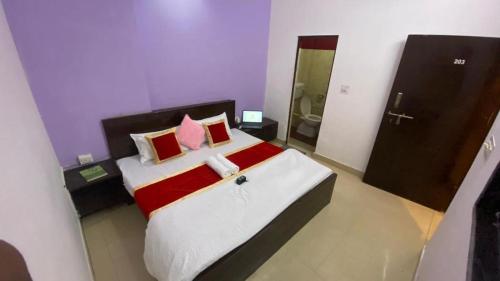a bedroom with a large bed with red and white pillows at Monkey Travel Hostel in Agra
