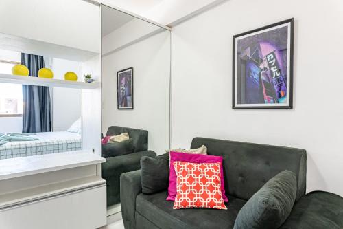 ein Wohnzimmer mit einem Sofa und einem Spiegel in der Unterkunft Apartamento com piscina in Recife