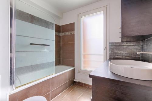 La salle de bains est pourvue d'un lavabo et d'une douche en verre. dans l'établissement Résidor - Sublime Appartement avec terrasse, à Saint-Ouen