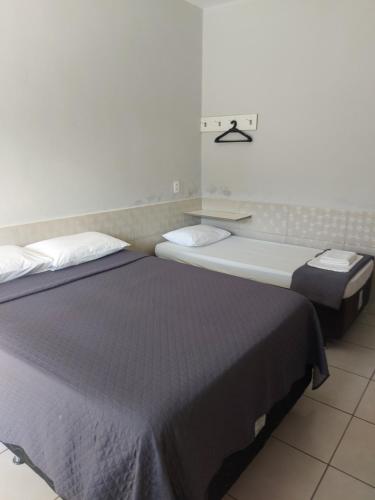 two beds sitting next to each other in a room at Estrela D Alva Pousada in Pirenópolis