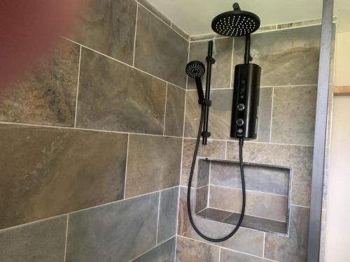 a shower with a shower head in a bathroom at Charming 1-Bed Apartment in Alfreton in Alfreton