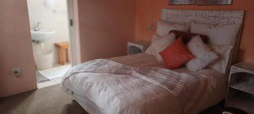 a bedroom with a bed with white sheets and pillows at Huis KlipdriftSelf Catering &B&B in Hentiesbaai
