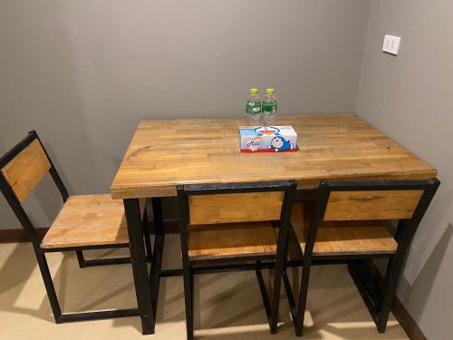 a wooden table with two chairs and a box of drinks at Saran Hostel krabi Thailand in Krabi town