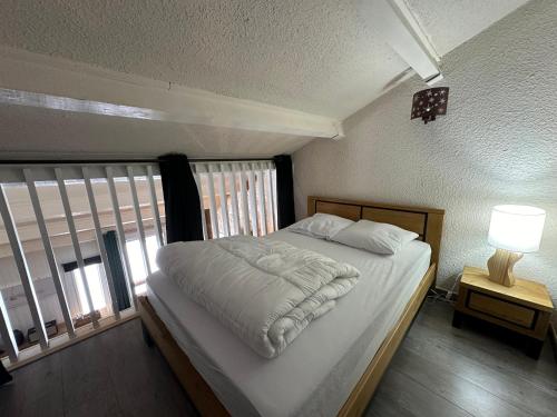 een slaapkamer met een wit bed en een raam bij Appartement Vars, 2 pièces, 7 personnes - FR-1-773-30 in Vars