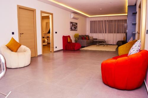 a living room with two red chairs and a couch at Villa Riad Arabic House Pool & Spa in Marrakech