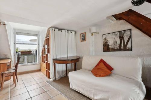 un salon avec un canapé blanc et une table dans l'établissement Le coeur de Paris, à Paris