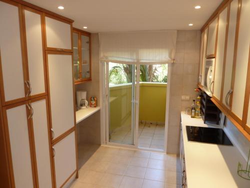 a kitchen with a glass door leading to a shower at Greenlife Village Apartment in Marbella