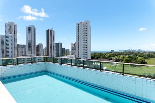 ein Pool auf dem Dach eines Gebäudes mit Skyline der Stadt in der Unterkunft Apartamento com piscina in Recife