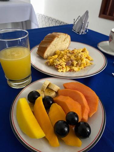 a table with two plates of food and a glass of orange juice at Hotel Boutique Iyarí in Palmira