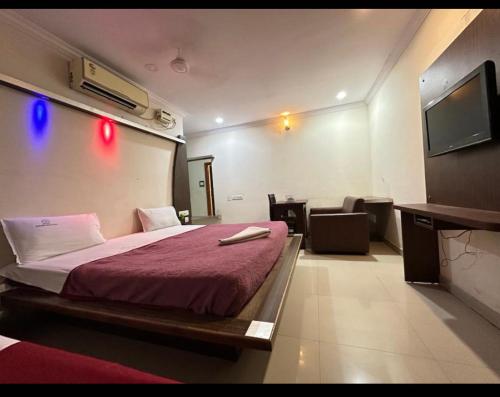 a hotel room with a bed and a flat screen tv at Siddi Vinayaka hotel in Hyderabad