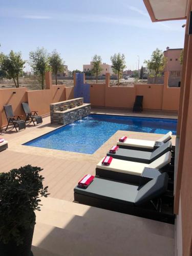 three lounge chairs sitting next to a swimming pool at Villa Riad Arabic House Pool & Spa in Marrakech
