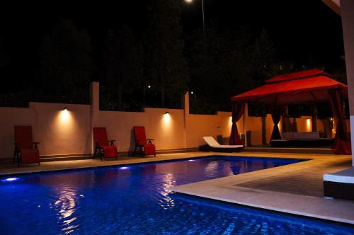 a swimming pool at night with a red umbrella at Villa Riad Arabic House Pool & Spa in Marrakech