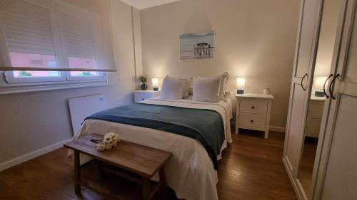 a small bedroom with a bed and a table at Apartamento Corbaceiras in Pontevedra