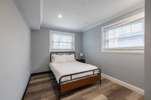 Cozy Updated 2BR Apartment in DC في واشنطن: غرفة نوم صغيرة بها سرير ونوافذ