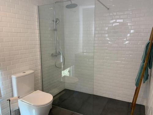 a bathroom with a toilet and a glass shower at Casa Jasmim in Sintra