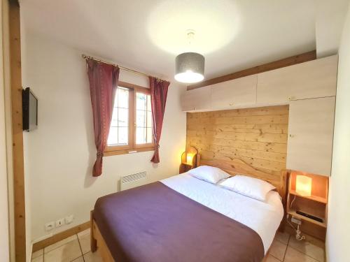 une chambre avec un grand lit et une fenêtre dans l'établissement Balcon des pistes - 217-218 - Appt tout confort 8p, à Les Deux Alpes
