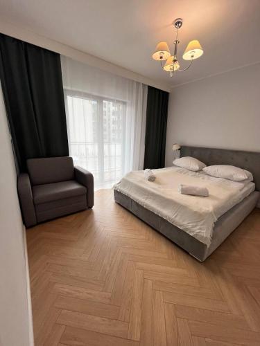 sypialnia z dużym łóżkiem i krzesłem w obiekcie Apartment OLD TOWN - Odra - Nice View - 2 Bathrooms we Wrocławiu