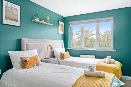 2 camas en una habitación con paredes azules en Entire 2 Bedroom Luxury Apartment with Free Parking, en Milton Keynes