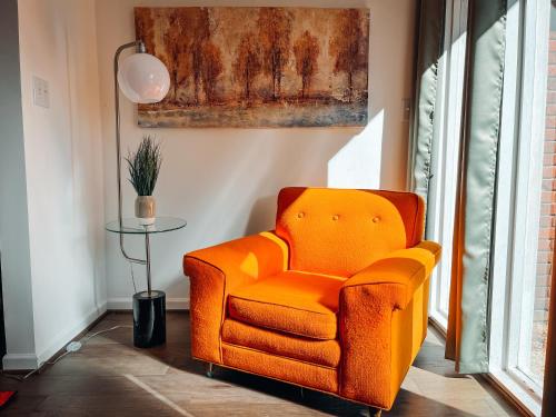 an orange chair in a room with a table at Cozy Guest House Studio Apartment in Greensboro