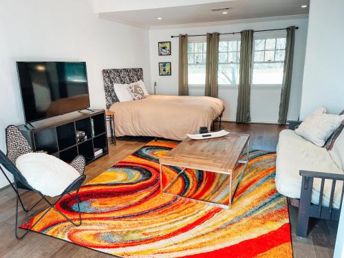 a living room with a bed and a rug at Cozy Guest House Studio Apartment in Greensboro