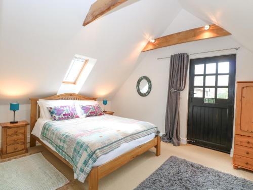 a bedroom with a bed and a window and a door at The Hayloft in Norwich