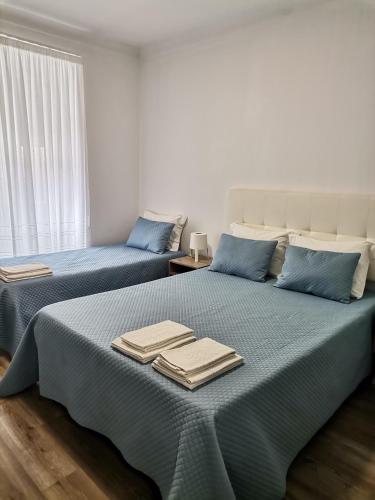 two beds in a room with towels on them at Baixinho Guest House in Vila Praia de Âncora
