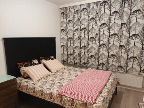 a small bedroom with a bed with a wallpaper at Centrally Located Studio Apartment in Espoo