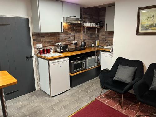 a small kitchen with two chairs and a counter top at Seaview Cottage 24 Freeman Street in Wells next the Sea