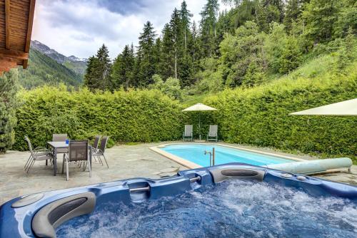 a swimming pool with a blue tub in a yard at Chalet Coeur in La Tzoumaz