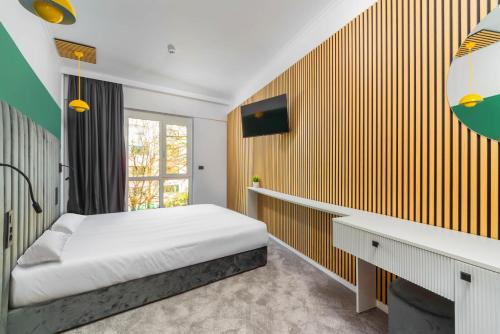 a bedroom with a bed and a desk and a window at URBAN BUDGET HOTEL in Timişoara