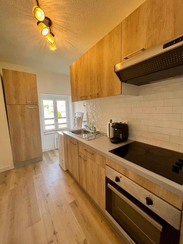 une cuisine avec des armoires en bois et un comptoir dans l'établissement Le Fleuri, à Lille