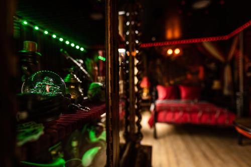 a living room with a red couch and a mirror at Le Cirque Ensorcelé - Le Studio Maudit & Cosy in Belfort