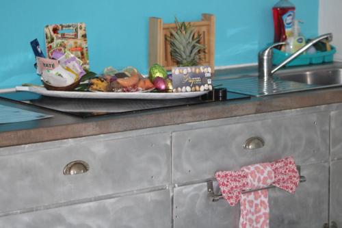 a kitchen counter with a plate of food on a sink at Le Colibri et le Frangipanier in La Trinité
